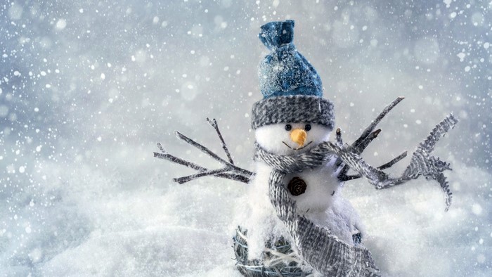 Snowman wearing a winter hat and scarf in the snow