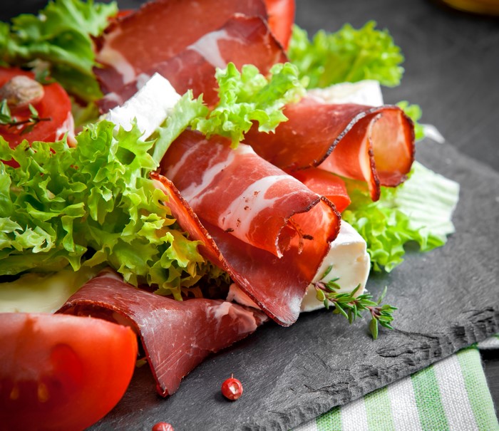 Charcuterie board with cured meats, cheese, and vegetables