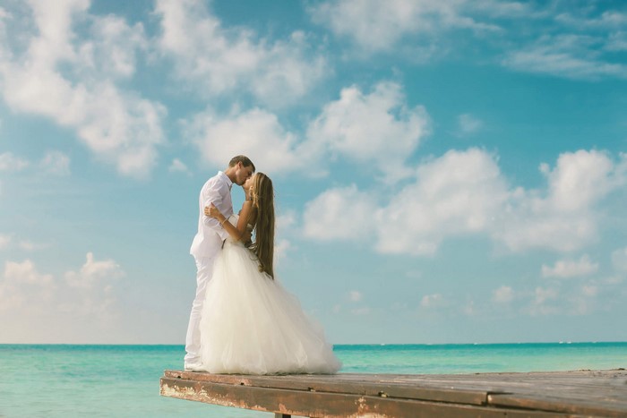 Bride and Groom kissing on a wooden pier