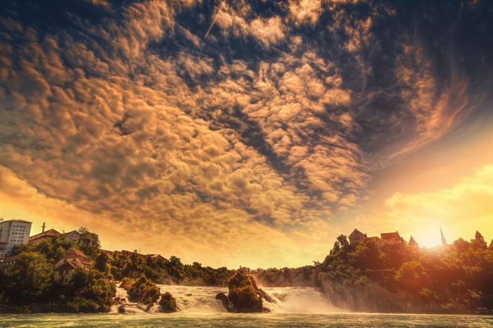 Waterfall with dramatic clouds at sunset