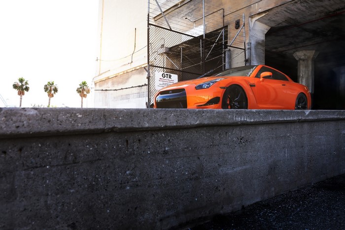 Orange Nissan GT-R R35 parked under a bridge
