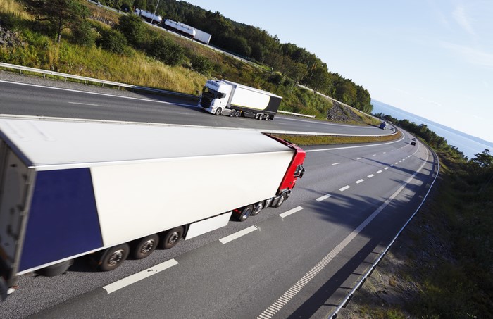 Trucks on a highway with a body of water