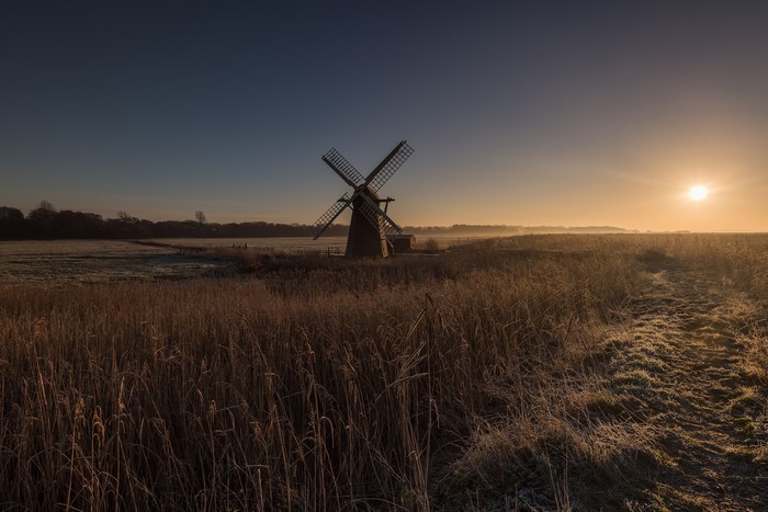 Windmill in a field at sunrise