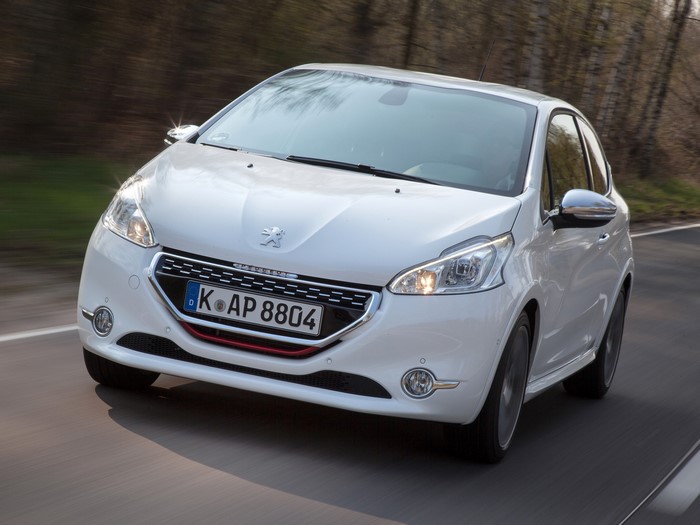 White Peugeot 208 GTI driving on a road