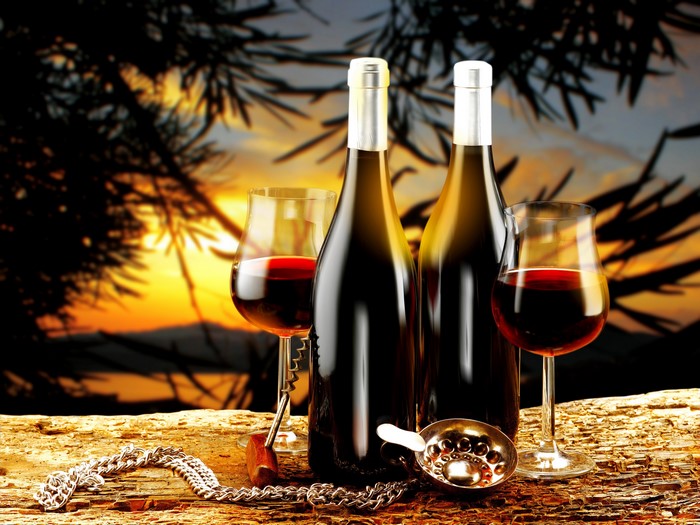 Two bottles of wine and glasses at sunset
