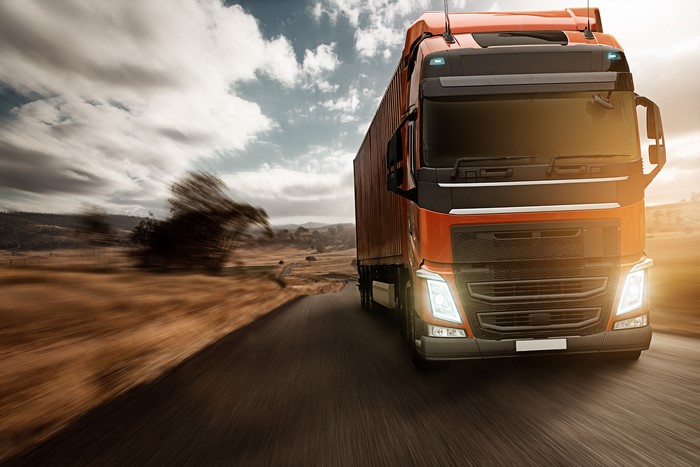 Orange truck driving on a road