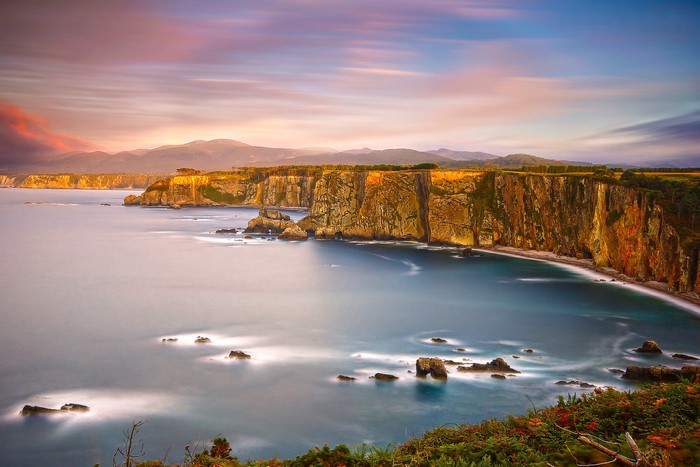 Coastal cliffs at sunset with calm sea