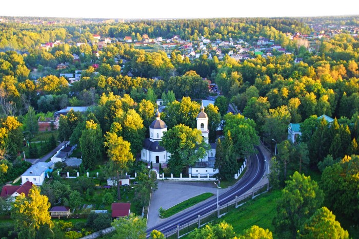 Church and houses in a forest near Moscow, Russia