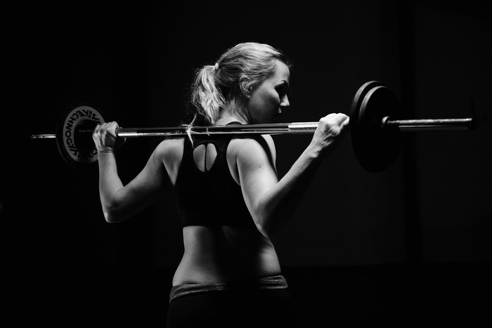 Woman lifting barbell in fitness center