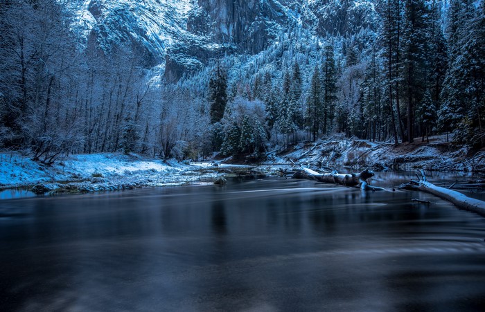 Winter scene in Yosemite National Park with a river and snow-covered trees