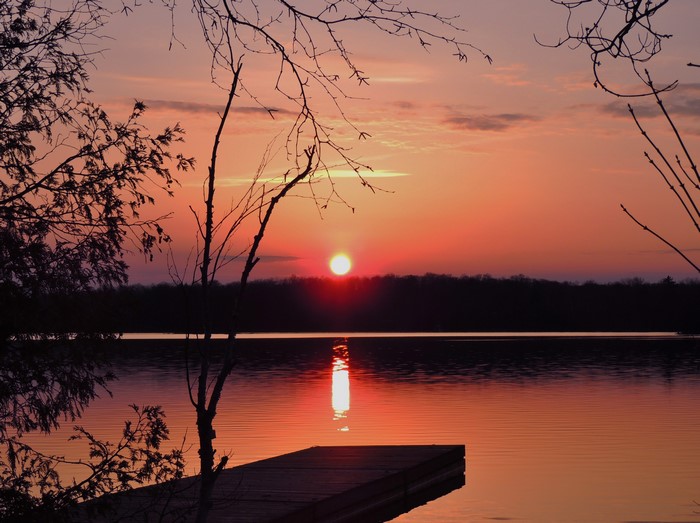 Sunset over a lake with a dock