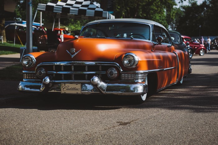 Orange Cadillac Series 62 at a car show