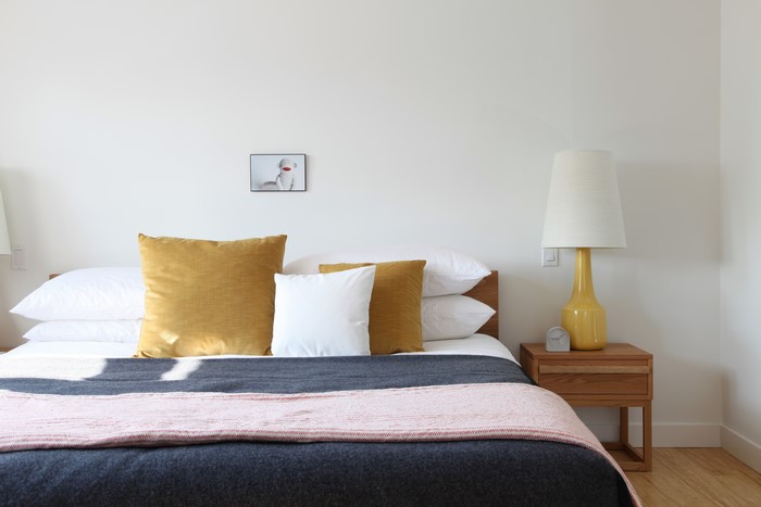 Bedroom with bed, pillows, and lamp