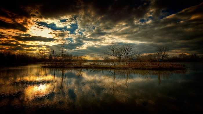 Dramatic sunset over a calm lake with reflections