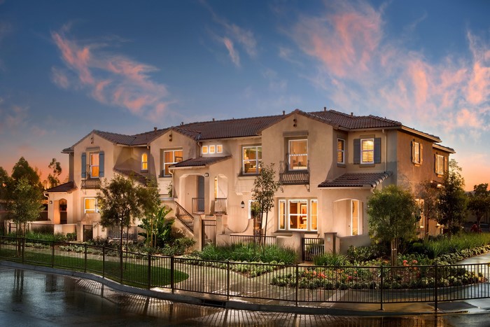 Townhouses with landscaping and fence at dusk