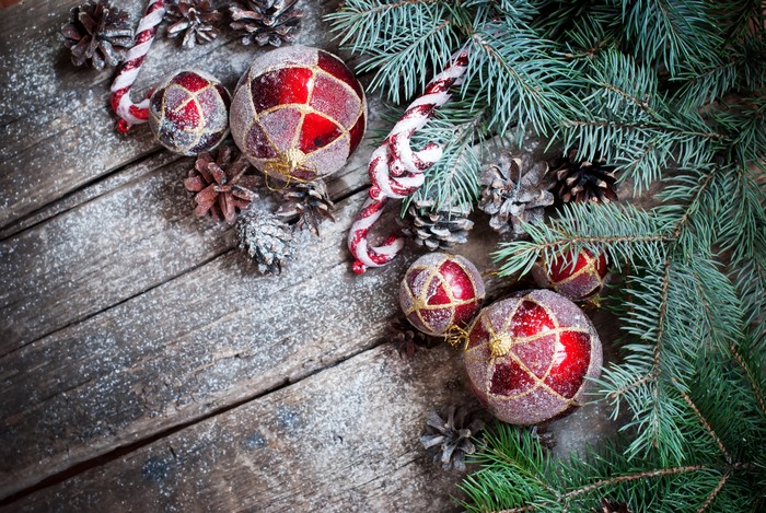 Christmas ornaments and pine cones on wood planks