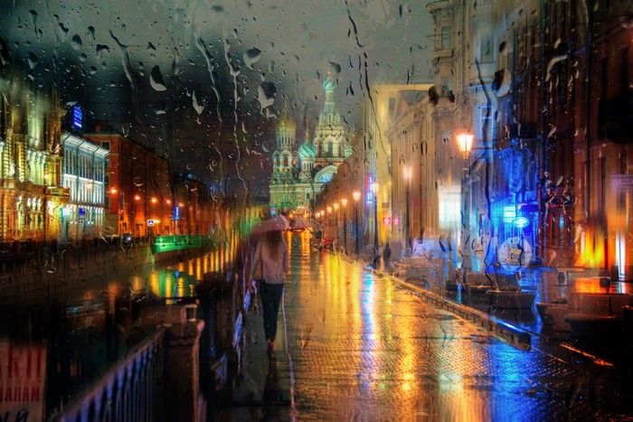 Person with umbrella walking on rainy street in St. Petersburg