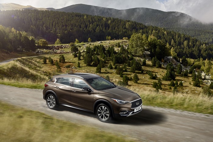 Brown Infiniti QX30 driving on a mountain road