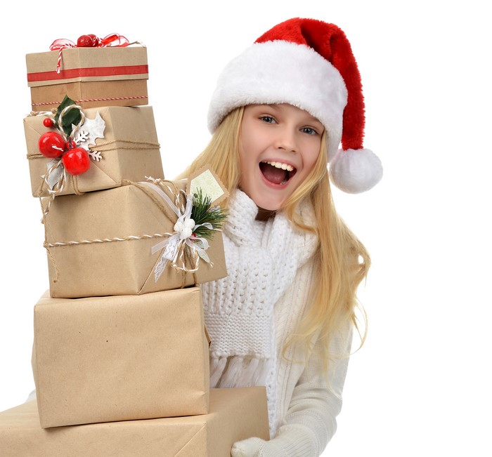 Blonde girl in Santa hat holding Christmas gifts