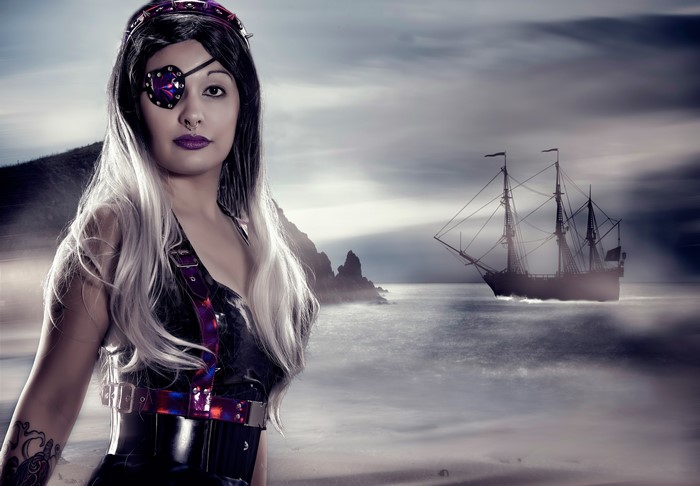 Pirate girl with eye patch and sailing ship