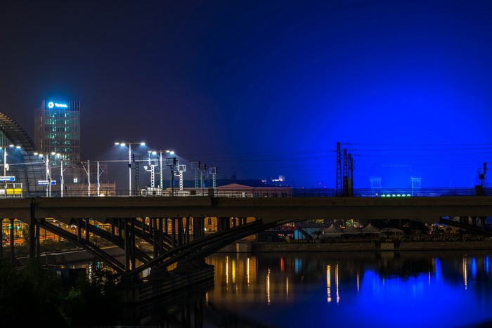 Bridge over river at night with city lights