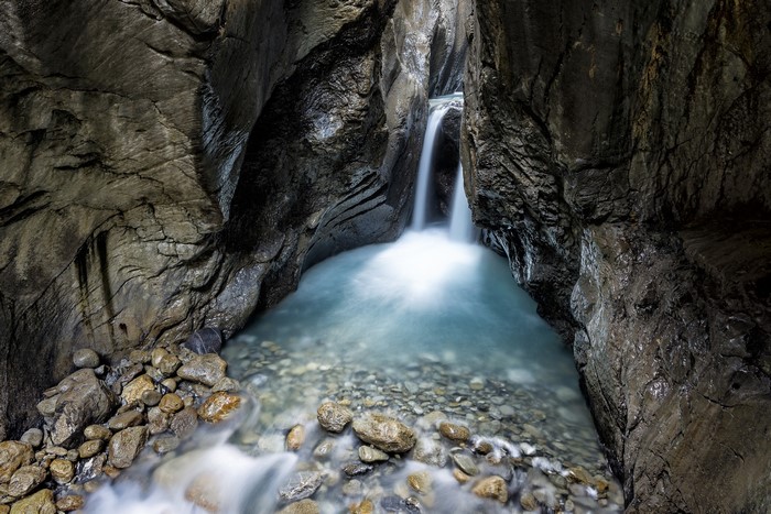 Waterfall flowing into a rocky canyon pool