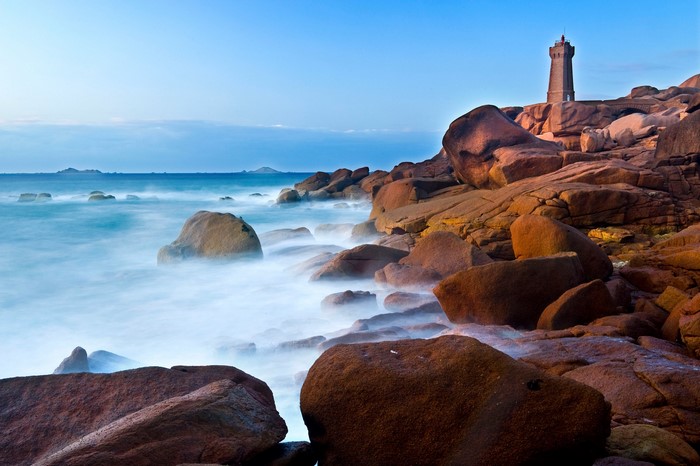 Lighthouse on a rocky coast with the sea