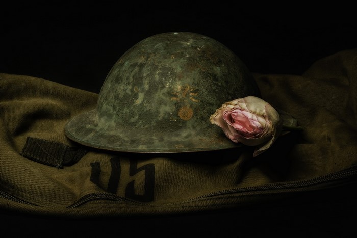 Old military helmet with a rose on a bag