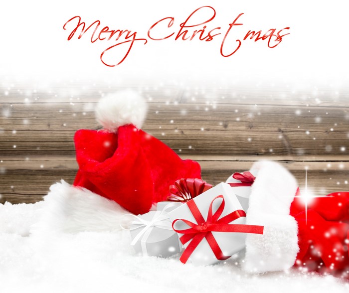 Christmas gifts and Santa hat in snow