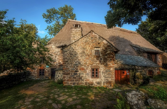 Stone house with thatched roof in Moudeyres, Auvergne, France