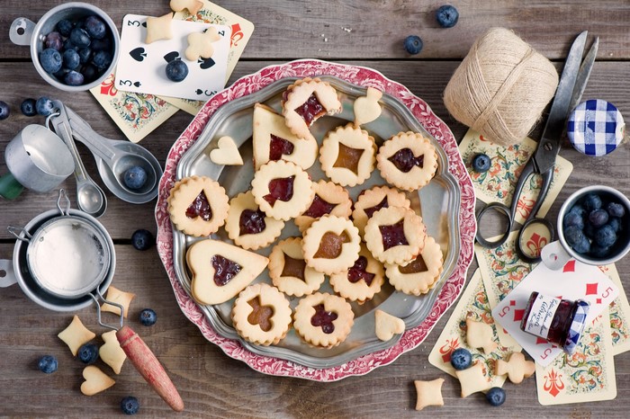 Cookies with jam and blueberries on a wooden table