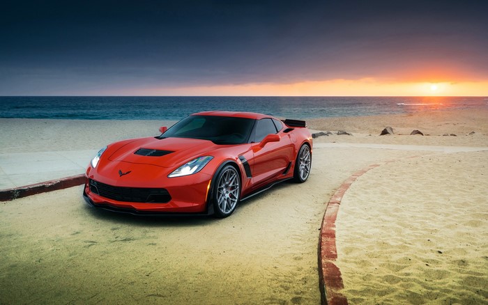 Red Chevrolet Corvette Z06 on a beach at sunset
