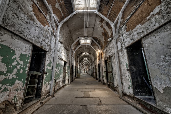 Abandoned prison hallway with cells
