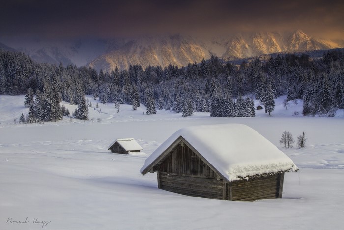 Snow-covered cabins in a winter mountain landscape