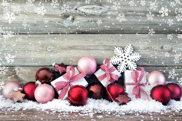 Christmas ornaments and gifts on wooden planks with snowflakes