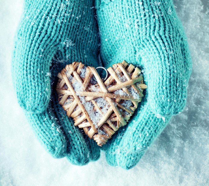 Hands in Gloves Holding a Heart in Snow