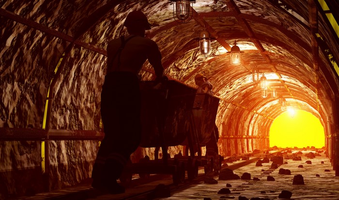 Miners pushing cart in a tunnel