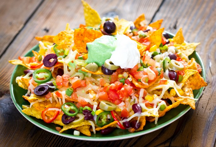 Plate of loaded nachos with toppings