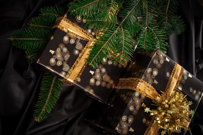 Christmas gifts with pine branches on black fabric