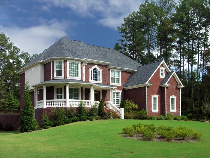 Brick Mansion with White Trim and Green Lawn