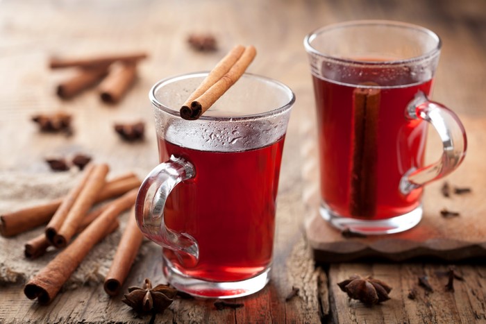 Two mugs of mulled wine with cinnamon sticks
