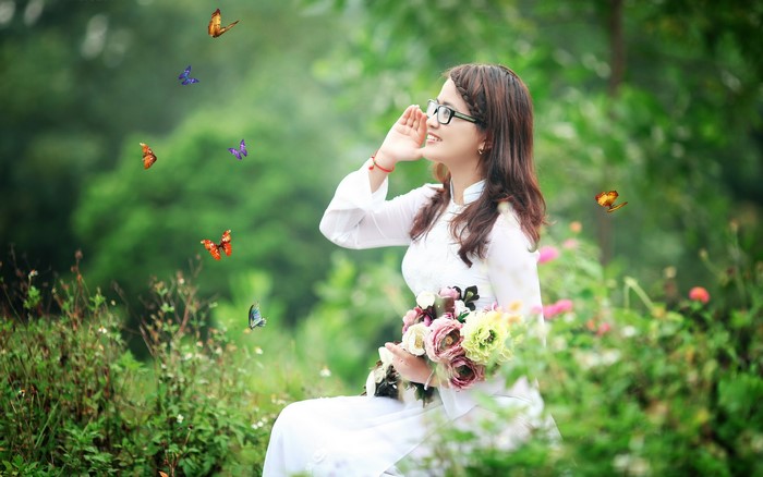 Woman in white dress with flowers and butterflies