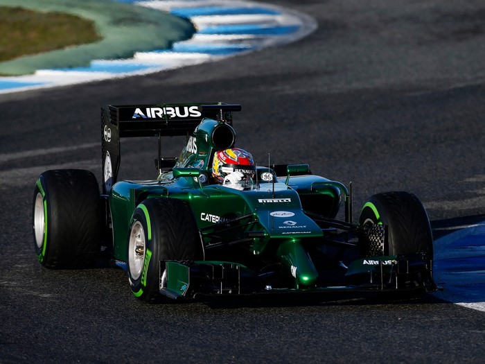 Green Caterham CT05 Formula 1 car on track