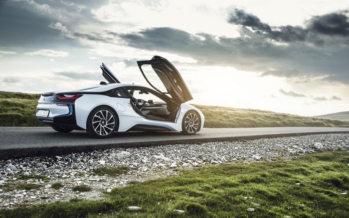 White BMW i8 with doors open on a road