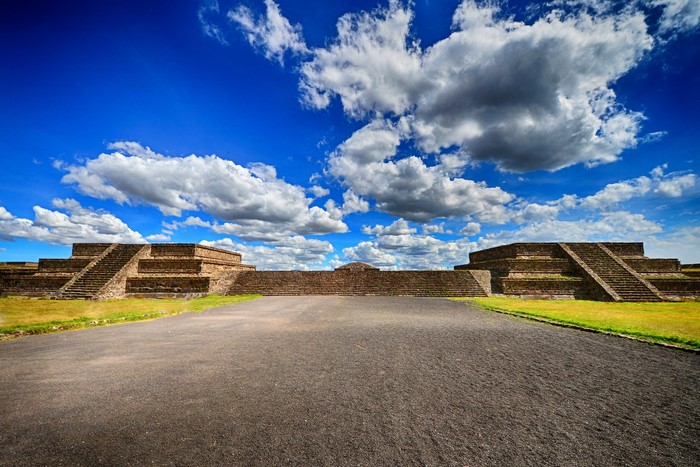 Ancient pyramids under a cloudy blue sky in Teotihuacan, Mexico