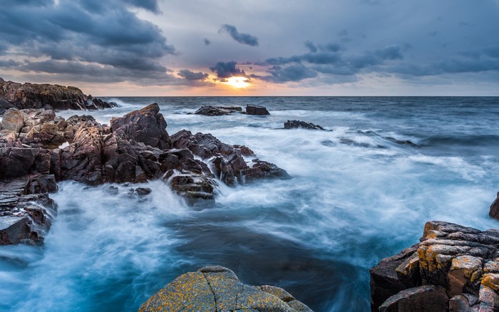 Rocky coast with waves crashing at sunset
