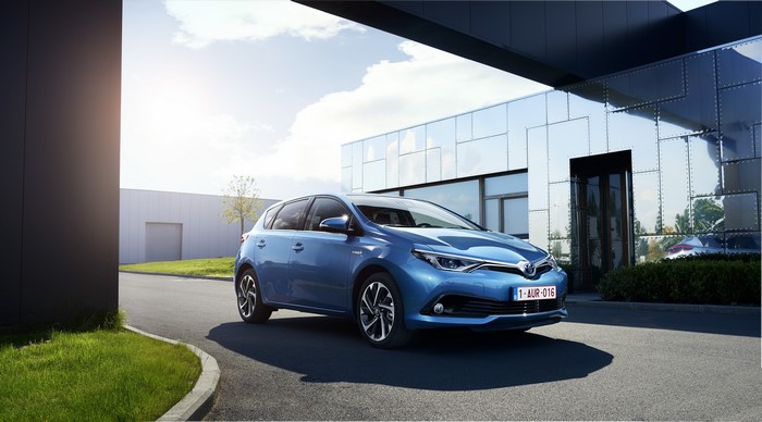 Blue Toyota Auris Hybrid parked outside a modern building