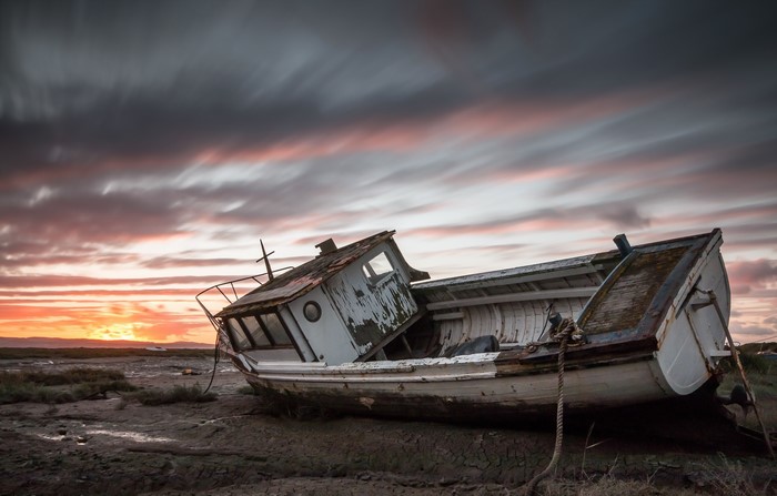 Abandoned Motorboat on Mudflat at Sunset