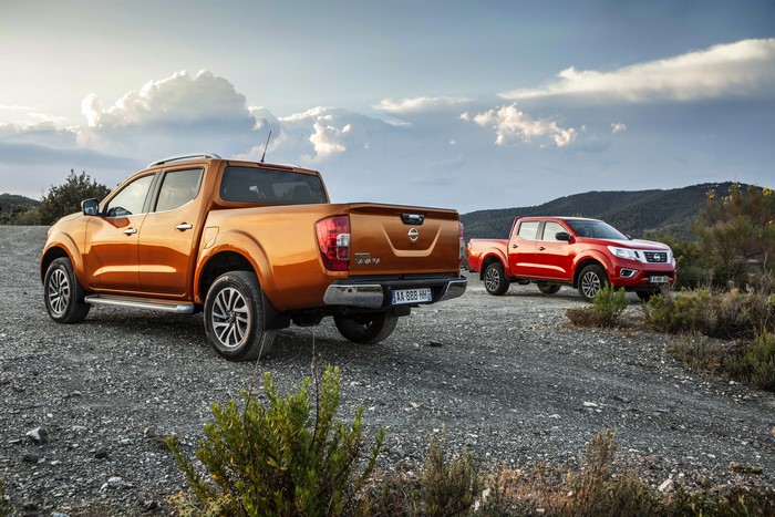 Two Nissan NP300 Navara pickup trucks in a landscape