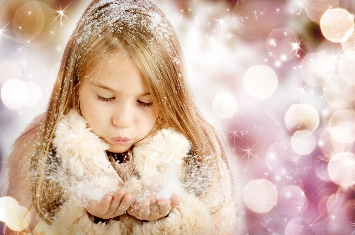 Girl blowing snow in winter